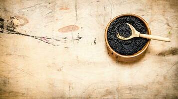 zwart kaviaar in een kom met een houten lepel. foto