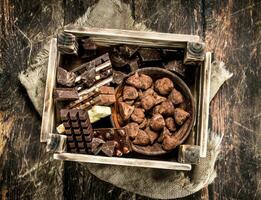 verschillend chocola en snoepgoed in een oud doos. foto