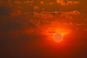 fenomeen van gedeeltelijke zonsverduistering boven zee en zonsonderganghemel foto