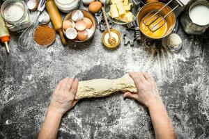 deeg achtergrond. vrouw kneedt deeg met divers ingrediënten Aan de tafel. foto