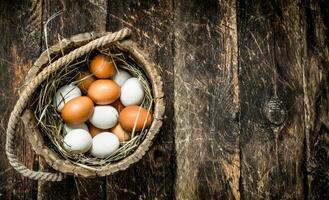 vers kip eieren in een oud houten emmer. foto