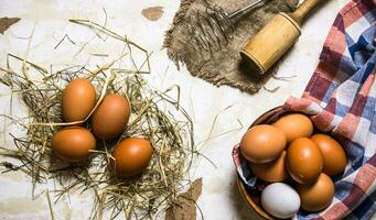 eieren in een kop met hooi en gereedschap - garde, stamper. foto