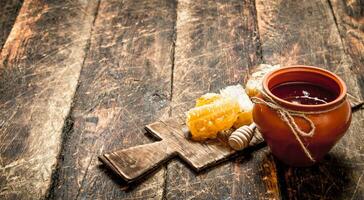 honing pot en honingraat met een houten lepel. foto