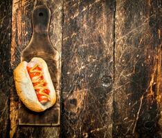 hotdog met mosterd Aan de oud bord. foto