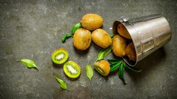 gedaald emmer met kiwi fruit en bladeren. foto