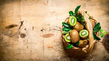 vers kiwi fruit in een oud mand met bladeren. foto