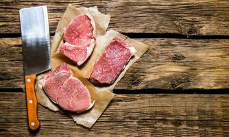 stukken van rauw vlees met een slager mes. foto