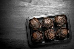 chocola muffins Aan een bakken vel. foto