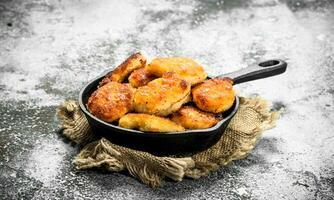 kip klompjes in een frituren pan. foto