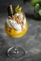 biologische mango en passievrucht tropische ijscoupe in wijnglas foto