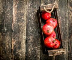vers granaatappels in een oud doos. foto