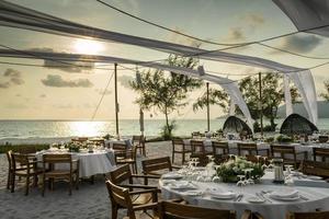 romantisch huwelijkstafelontwerp bij zonsondergang buiten op tropisch Aziatisch strand in Bali Indonesië