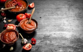 tomaat saus met knoflook in houten kommen. foto