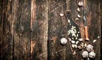 de pittig knoflook Aan de oud bord. Aan de oud houten tafel. foto