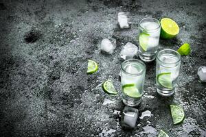 wodka met stukken van limoen en ijs kubussen. foto