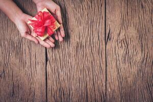 bovenaanzicht hand met geschenkdoos op hout achtergrond. foto