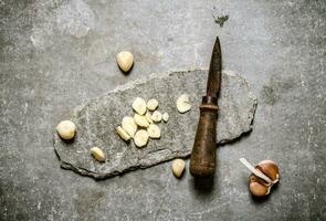 gehakt knoflook en oud mes Aan een steen stellage. foto