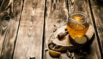 honing in een pot met noten en appel plakjes. foto