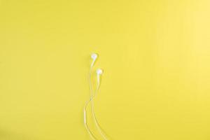 witte oortelefoon een gele achtergrond. foto