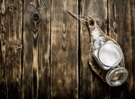 zout in een glas pot Aan houten bord foto