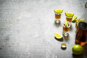 fles van tequila met limoen en zout. foto