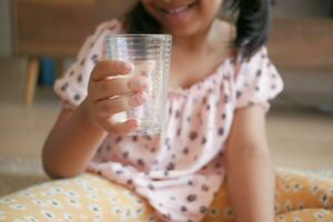 kind hand- Holding een glas van water foto