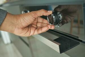 mannen hand- instelling temperatuur controle Aan oven. foto