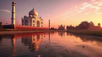 een adembenemend zonsondergang over- de mooi taj mahal, een verbijsterend wit marmeren paleis reeks langs een lichaam van water. net zo de zon sets foto