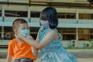 twee kinderen dragen een mis ter bescherming tegen het coronavirus foto