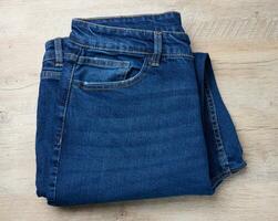 gevouwen blauw jeans Aan een houten achtergrond, top visie foto