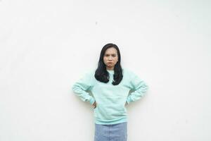portret Indonesisch mooi vrouw vervelend licht blauw trui boos gebaar geïsoleerd Aan wit achtergrond foto