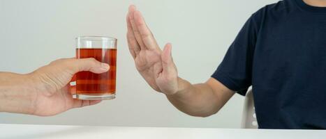 Mens weigert zeggen Nee en vermijden naar drinken een alcohol whisky , stoppen hand- teken mannelijk, alcoholisme behandeling, alcohol verslaving, stoppen drank, hou op drinken alcohol. weigeren glas likeur, ongezond, afwijzen foto