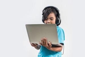 klein meisje met behulp van laptopcomputer en luisterles online. foto
