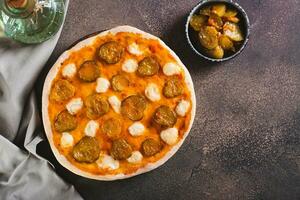 pizza met augurken en Mozzarella Aan een houten bord Aan de tafel top visie foto
