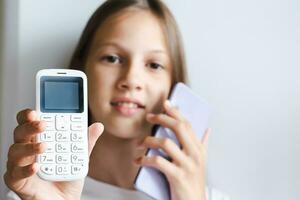 dichtbij omhoog van wit druk op de knop telefoon in de hand- van een meisje met een smartphone foto