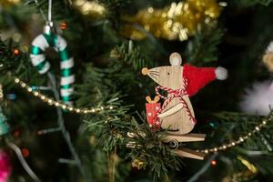 een houten muis in een de kerstman hoed en een karamel riet foto