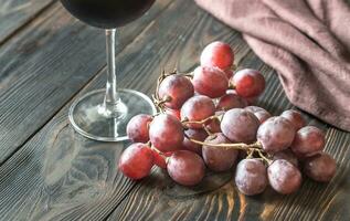 glas van rood wijn met bundel van rood druif foto