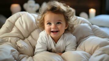 schattig baby meisje met gekruld haar- aan het liegen Aan bed Bij huis. foto