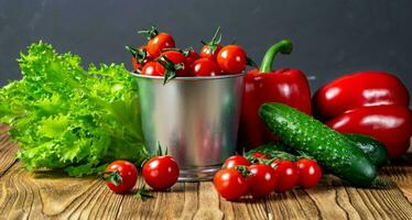 reeks van groenten voor salade, komkommers, klok pepers, vers rood kers tomaten Aan een houten tafel bovenzijde visie. oogst. natuurlijk voedsel. foto