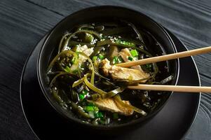 Koreaans zeewier soep met vlees in zwart schaal. verjaardag soep. Koreaans keuken. gezond voeding. zwangerschap. visie van bovenstaande. traditie. Op maat. foto