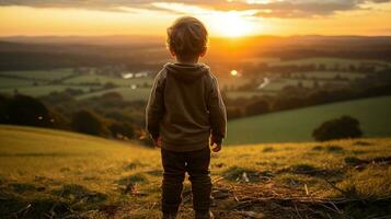 een jong jongen staand Aan een heuvel op zoek Bij de zonsondergang generatief ai foto