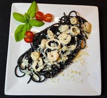spaghetti rigate - zwarte pasta met gemengde zeevruchten foto