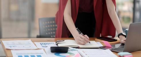 zakenvrouw die op kantoor werkt met laptop en documenten op zijn bureau foto