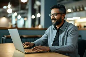 Mens tafel knap Indisch laptop binnenshuis computer freelancer technologie levensstijl vrolijk huis glimlach bedrijf gebruik makend van online foto