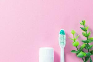 pastel roze achtergrond met schoonmaak gereedschap voor mondeling en tandheelkundig Gezondheid zorg zo net zo tandenborstel en tandpasta. levensstijl en dagelijks routine- voor een gezond mond en tanden. foto