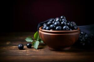 vers acai fruit in een klei kom Aan houten tafel. zwart achtergrond ai gegenereerd foto