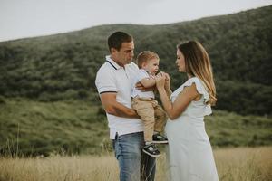 jong gezin met schattige kleine jongen die plezier heeft buiten in het veld foto