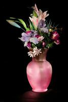 een roze vaas met bloemen foto