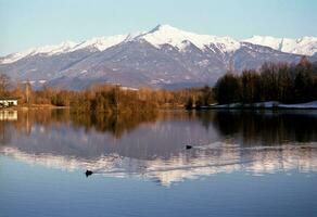 sereen schoonheid blauw meer in savoie met sneeuw afgedekt bergen foto