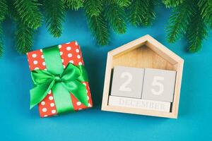 top visie van Spar boom, houten kalender en geschenk doos Aan kleurrijk achtergrond. de twintig vijfde van december. vrolijk Kerstmis tijd met leeg ruimte voor uw ontwerp foto